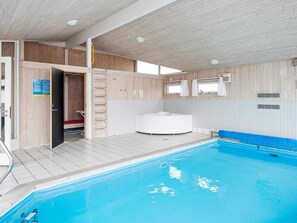 Uima-allas, jonka yhteydessä on puinen terassi, poreallas ja sauna.