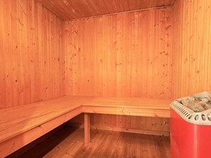 Sauna, jonka seinät ja penkit ovat tehty puusta.