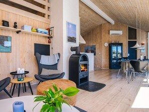 A modern interior with a fireplace, seating area, and wooden walls. - 10 Person Holiday Home in Fano (Fano)