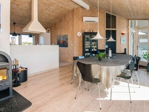 A modern interior with a dining area, wooden walls, and a fireplace. - 10 Person Holiday Home in Fano (Fano)