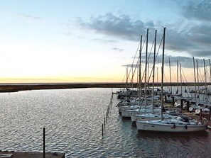 Eine Marina mit mehreren Segelbooten, ruhigem Wasser und blauem Himmel.