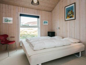 A room with a bed, a chair, a window, and artwork on the walls. - 4 Star Holiday Home in Fano (Fano)