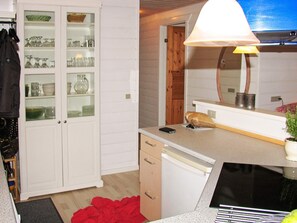 Eine Küche mit einem weißen Schrank, einer Arbeitsplatte, einem Spülbecken und einem roten Tuch auf dem Boden.