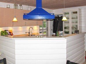 A kitchen with a central island, a sink, and overhead lighting.