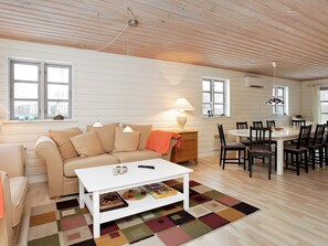 A cozy living room with a sofa, coffee table, and dining area.