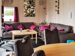 A cozy living room with a sofa, armchairs, a coffee table, and a dining table. - Holiday Home in Otterndorf (Otterndorf)