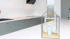 A modern kitchen with a built-in stove, a window, and a pendant light. - 6 Person Holiday Home in Lokken-by Traum (Lokken)