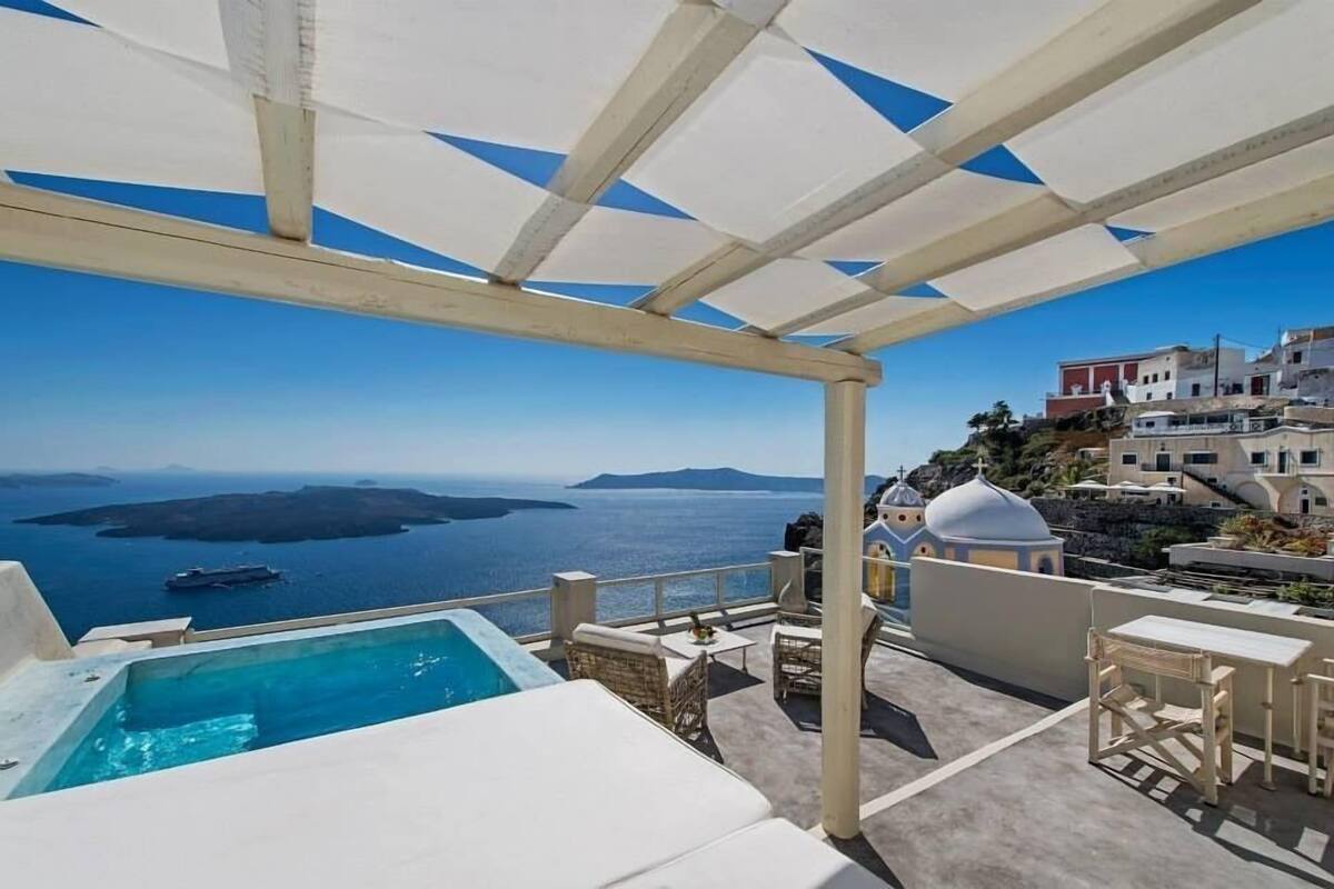 A rooftop terrace with a pool, outdoor seating, and a view of the sea and islands.