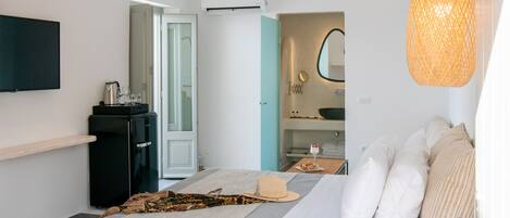 A modern bedroom with a bed, bedside table, and a TV mounted on the wall.