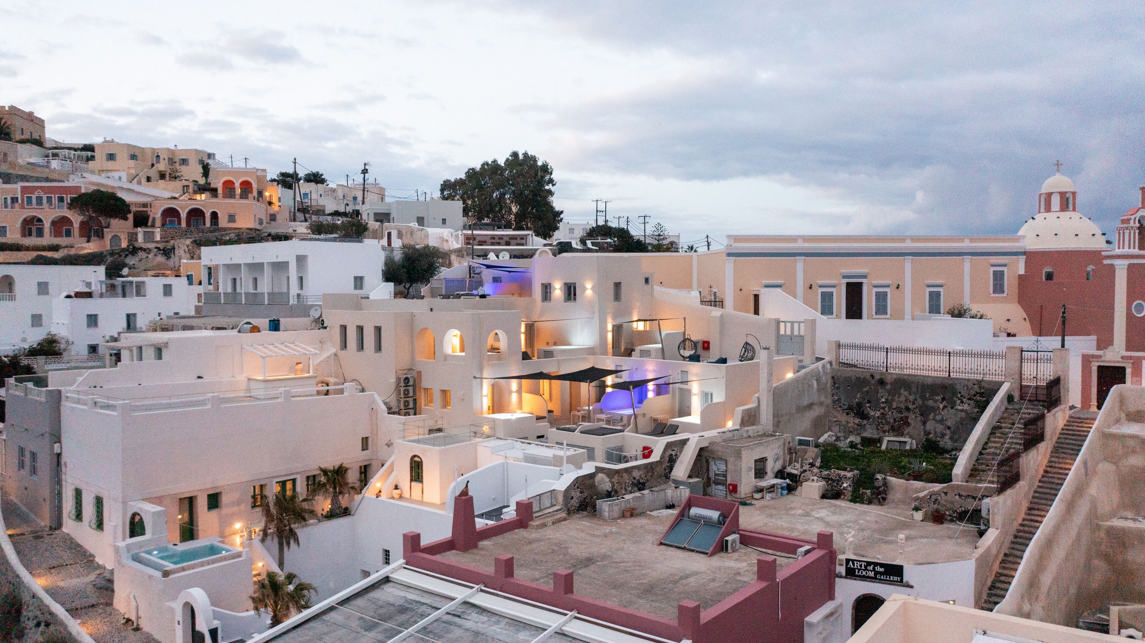 A rooftop terrace with outdoor seating, a pool, and a view of the surrounding buildings.