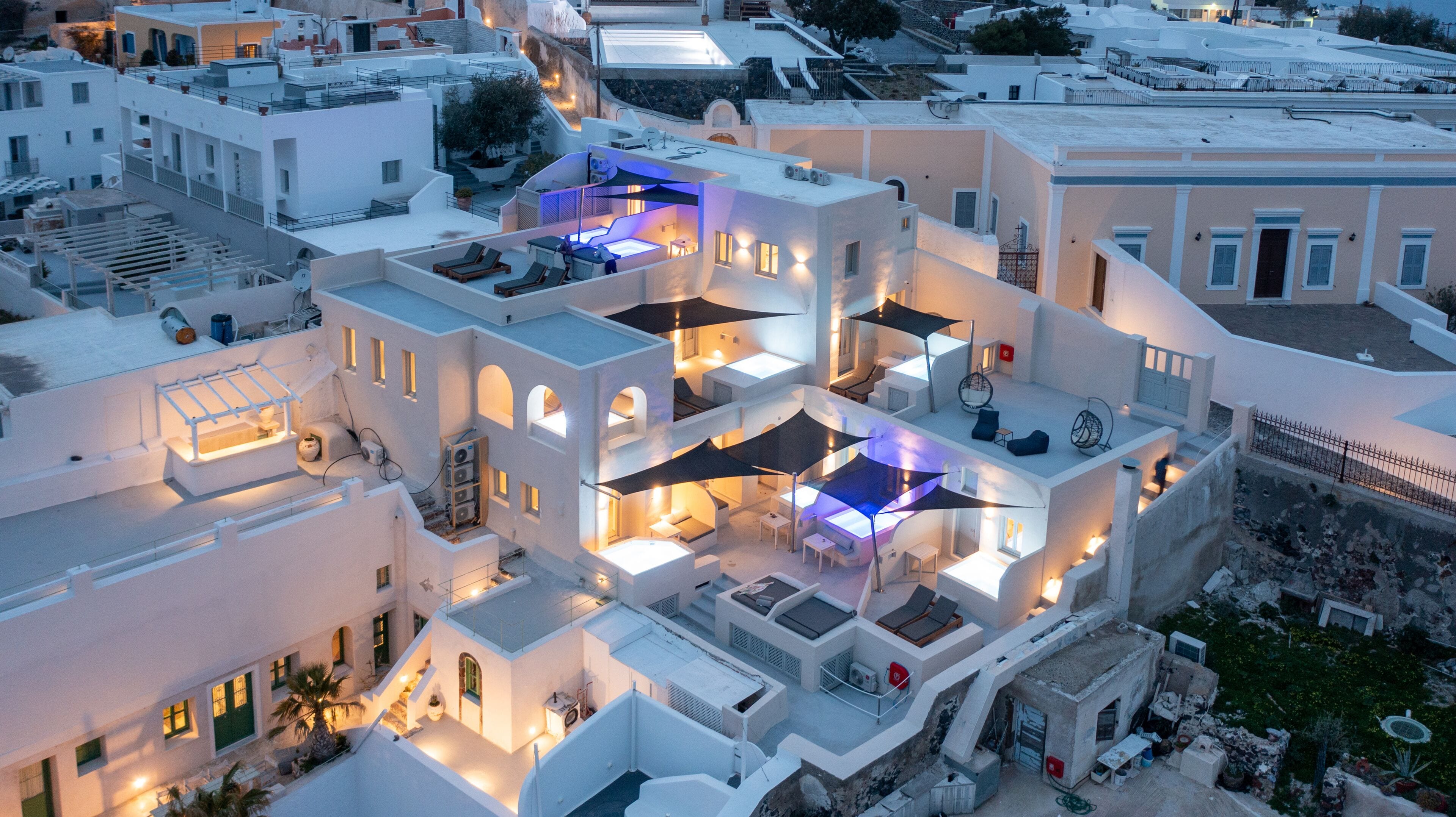 Un immeuble à plusieurs étages doté de balcons, d’un espace extérieur aménagé avec des sièges et d’une piscine.
