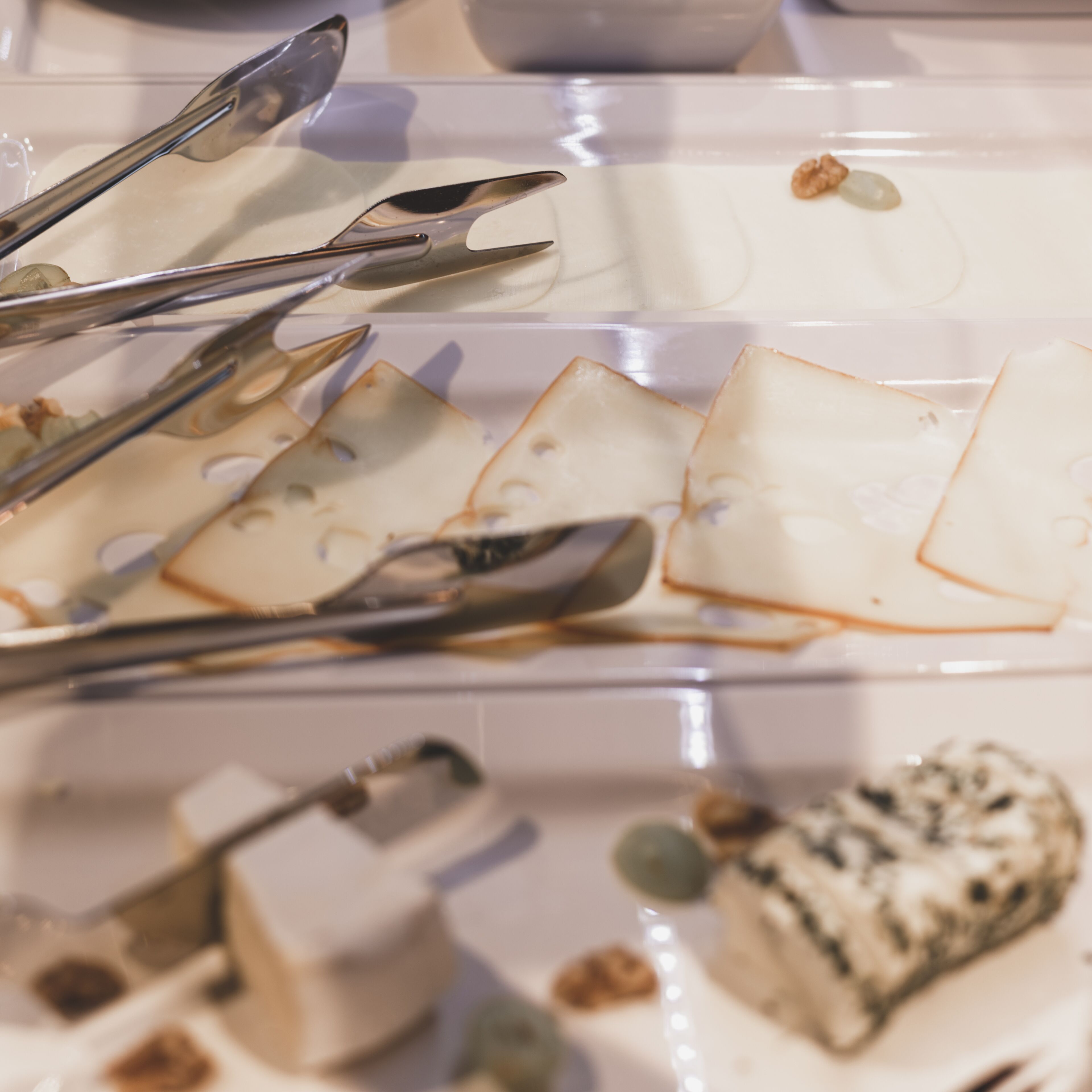 Una vista clara de un plato de postres con varios elementos, incluyendo un pedazo de pastel, nueces y una cuchara.