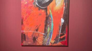 Una pintura de un loro en una pared roja.