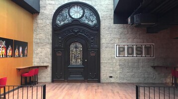 A lobby with a large ornate black door, a 'PDS' sign, and red chairs.