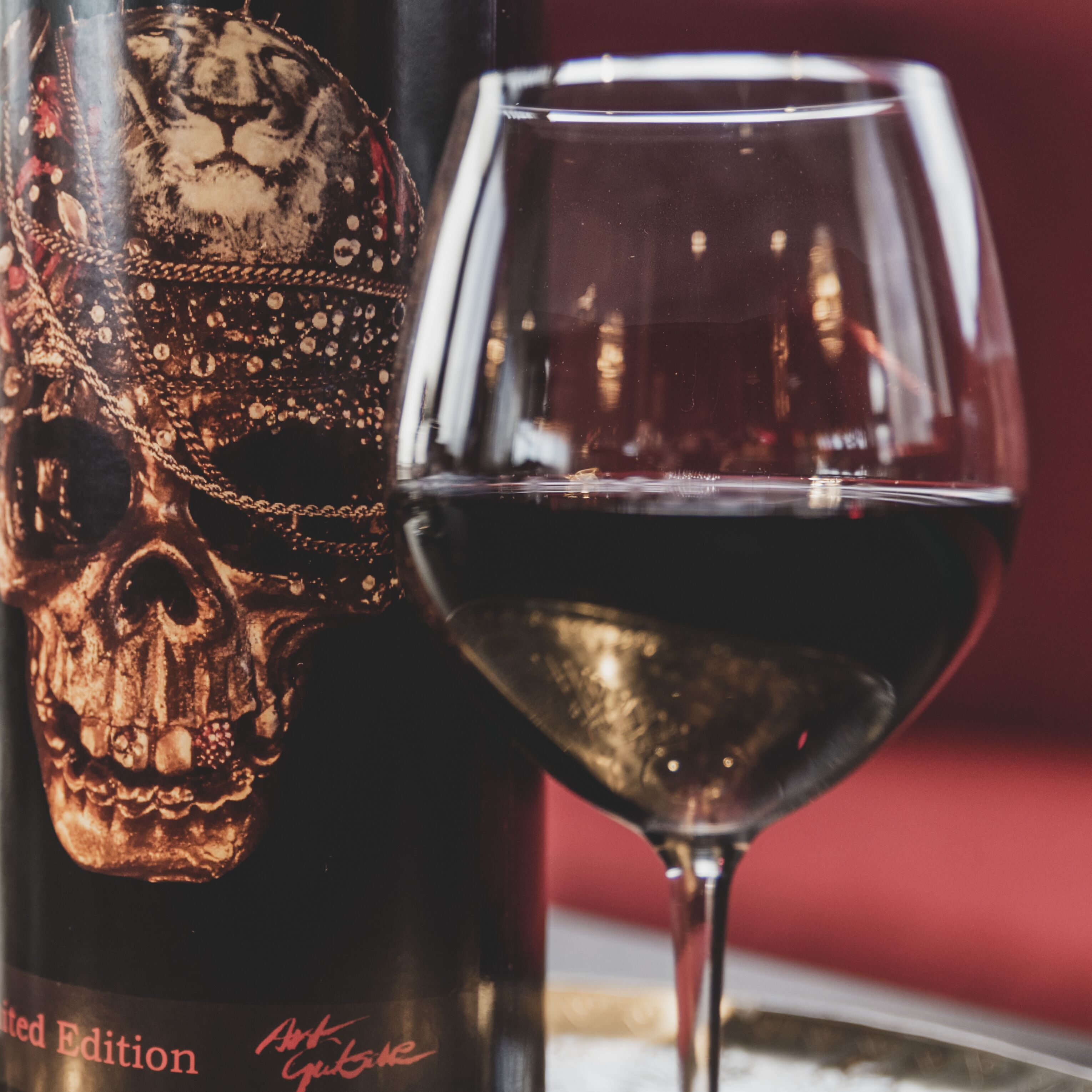 Una botella y una copa de vino con diseño de calavera.
