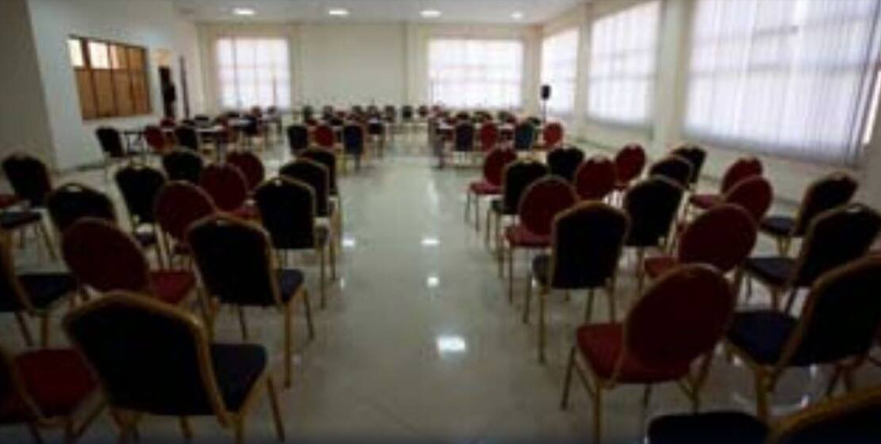 A conference room with rows of chairs arranged for a meeting.