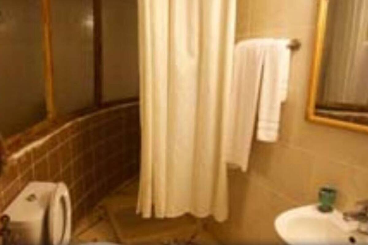 Un bany amb dutxa, un lavabo i un mirall.