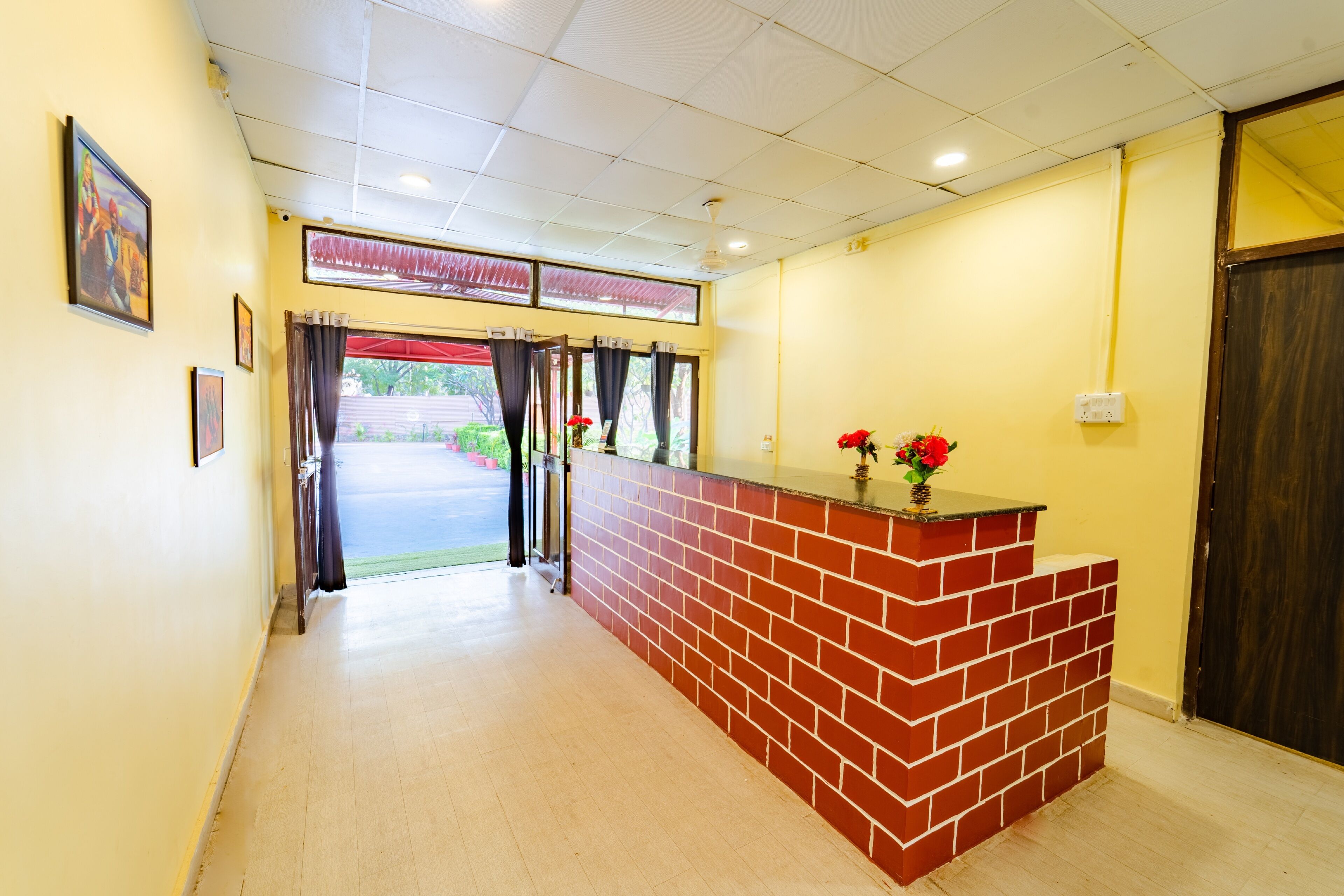 A reception area with a brick counter, a door, and a view of the outside.