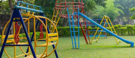 Un parque infantil con columpios, toboganes y estructuras para escalar.