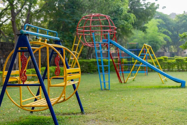 Un parque infantil con columpios, toboganes y estructuras para escalar.