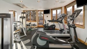 Ein Fitnessstudio mit Laufbändern, Crosstrainern und Krafttrainingsgeräten.