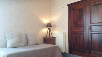 Une chambre à coucher avec un lit, une table de chevet, une lampe et une armoire.