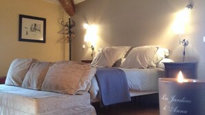 Un dormitorio acogedor con cama, sofá y una vela encendida sobre una mesa.
