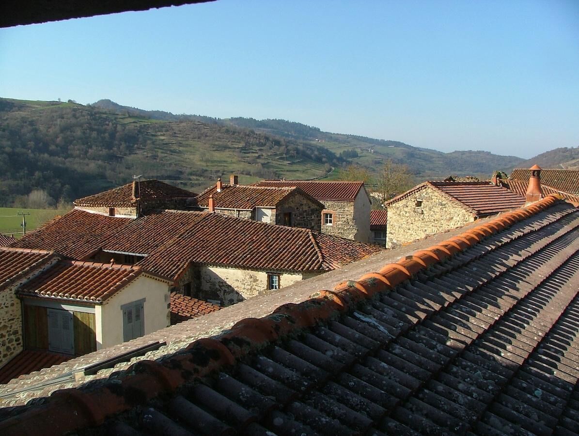 A terraced hillside with stone buildings and red-tiled roofs.