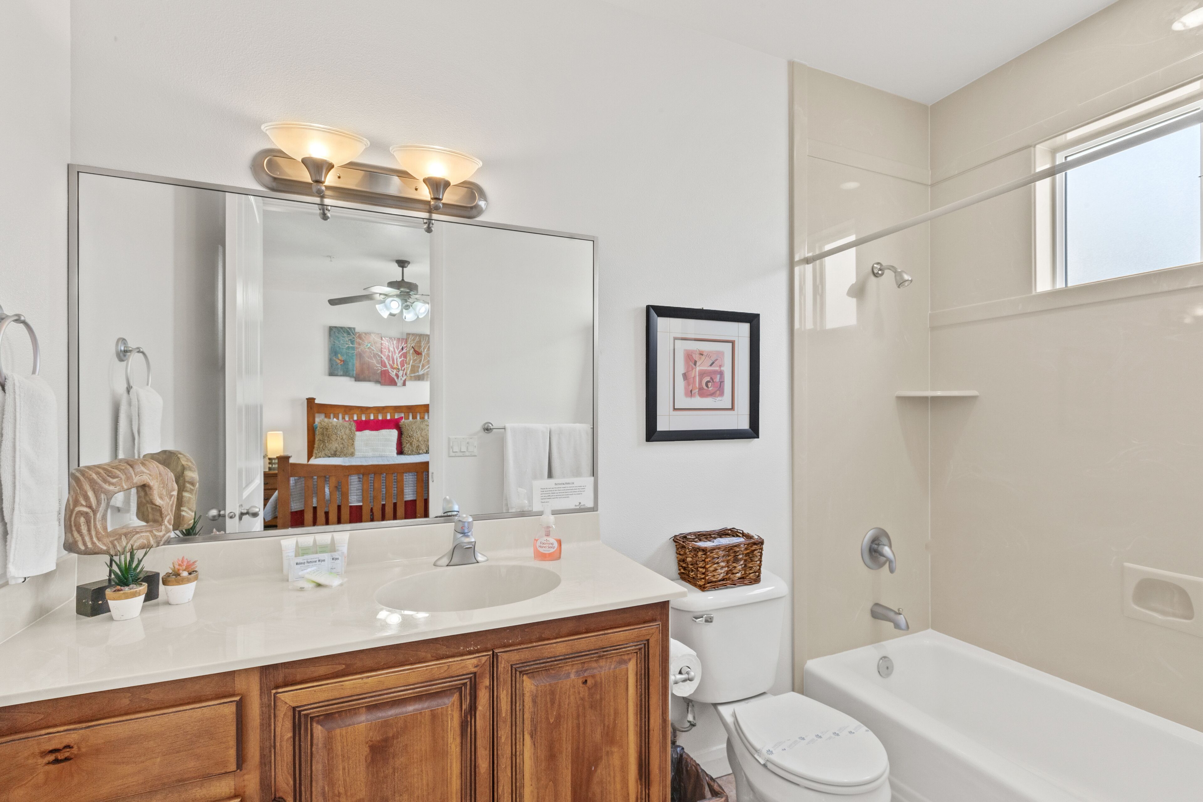 Une salle de bain moderne avec un grand miroir, un meuble-lavabo, un lavabo et une baignoire.