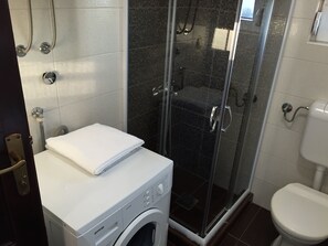 Regadera, secadora de cabello, toallas, papel de baño 