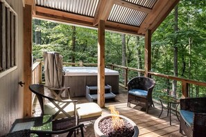 A wooden deck with outdoor seating, a hot tub, and a fire pit.