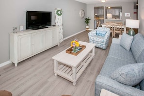 Relax in this stylish living room with a flat-screen TV, comfortable sofa, and cozy armchair.