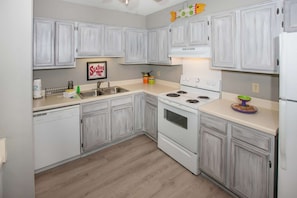 Enjoy cooking in this kitchen with a sink, stove, and ample countertop space.