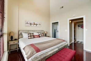 Cozy retreat with a large bed, wooden headboard, and wall-mounted artwork.