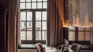 A room with a large window, a long wooden table, and a chair. - Broederenklooster (Zutphen)