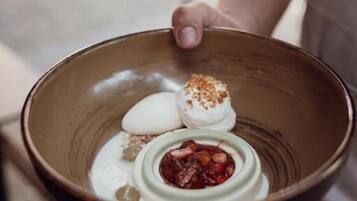 A person holding a bowl with a dessert.
