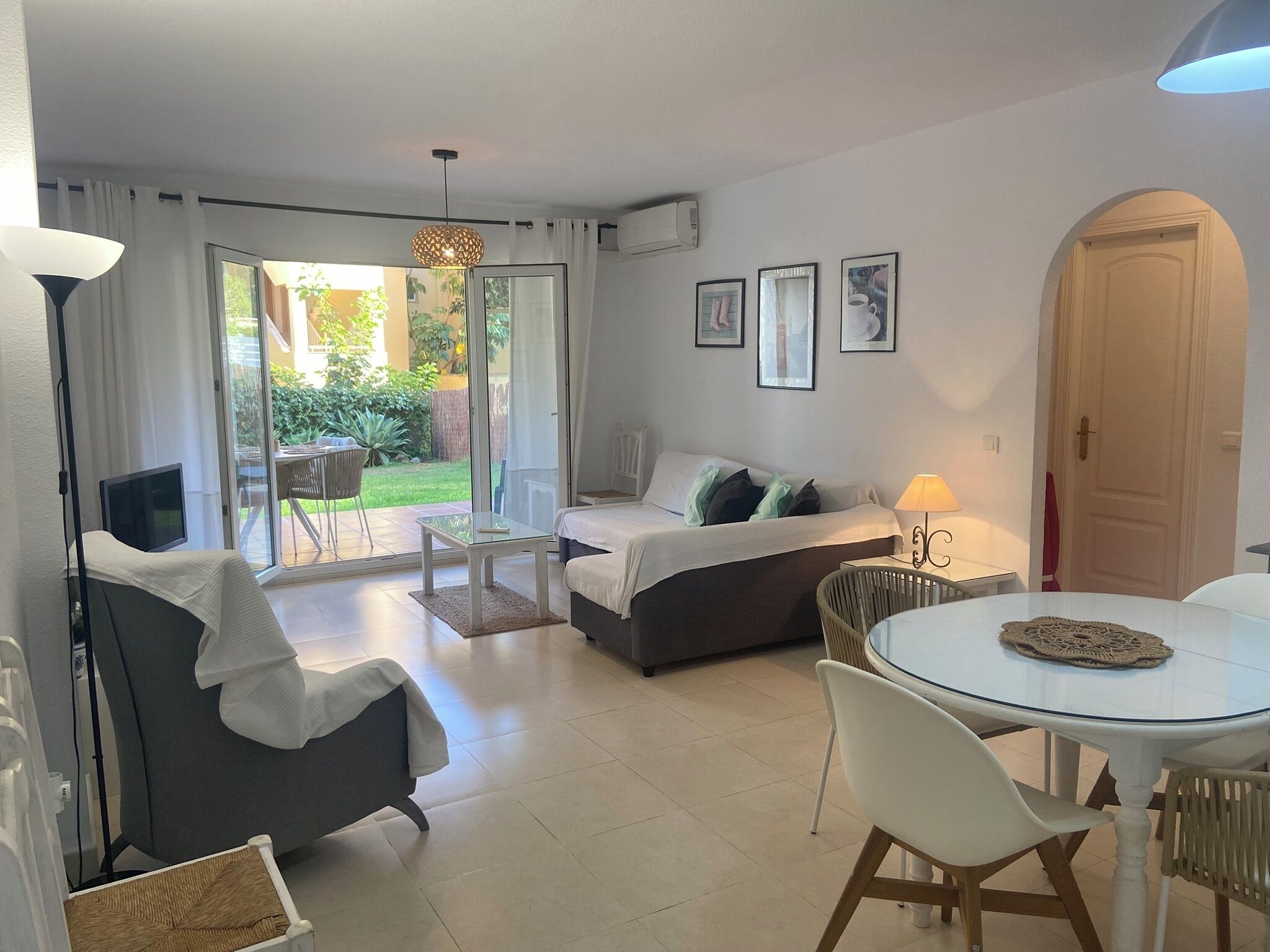 Quarto moderno com cama, mesa de jantar e televisão.