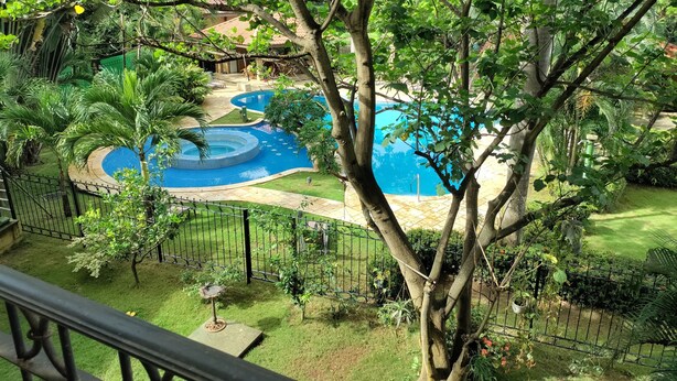 A pool surrounded by lush greenery, with a clear view of the surrounding landscape. - Spacious 3/2/ condo located minutes from downtown area of Beautiful Tamarindo  (Tamarindo)