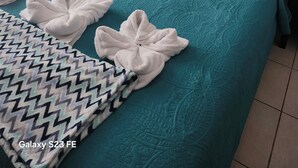 A neatly made bed with a teal quilt, white pillows, and towels arranged on the bed. - Spacious 3/2/ condo located minutes from downtown area of Beautiful Tamarindo  (Tamarindo)