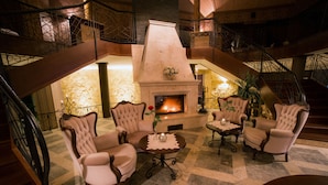 A lobby with a fireplace, seating area, and a staircase.