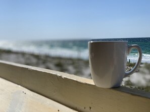 A white mug on a wooden railing overlooking the ocean. - Directly on the beach! 2 beach chairs and 1 umbrella provided! (Destin)