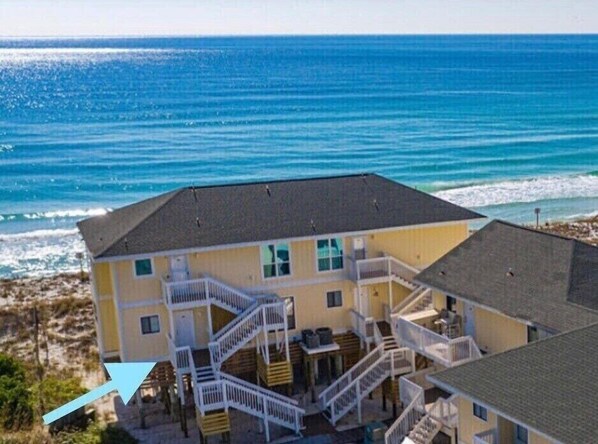 A coastal building with multiple balconies and a staircase leading to the upper floor. - Directly on the beach! 2 beach chairs and 1 umbrella provided! (Destin)