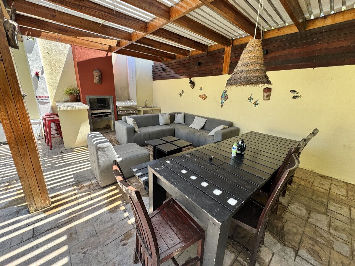Eine Terrasses mit Esstisch, Stühlen und einer Couch.