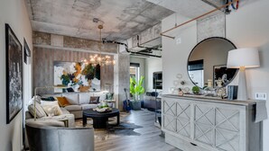 A modern living room with a sofa, coffee table, and a decorative mirror. - MINNeSTAY* Sable 501 - Luxury Two Story Loft | North Loop | Target Center (Minneapolis)