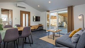 Un salon moderne comprenant un coin repas, un canapé et un téléviseur.
