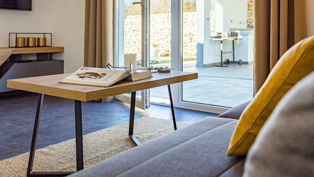 Un salon moderne avec un canapé, une table basse et une grande fenêtre.