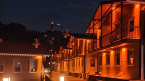 A street at night with buildings illuminated by warm lighting. - Kaya Life Resort (Çaykara)