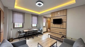 Suite – comfort, balkong | Oppholdsområde | En 80-centimeters TV med Parabol-TV samt oppvarmet gulv