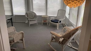 A room with four wicker chairs, a small table, and a unique hanging light fixture. - one block to the boardwalk and the beach (Ventnor City)