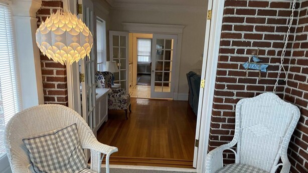 A room with wicker chairs, a checkered cushion, and a hanging light fixture. - one block to the boardwalk and the beach (Ventnor City)